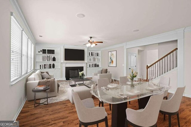 dining area featuring built in features, ceiling fan, dark hardwood / wood-style floors, and crown molding