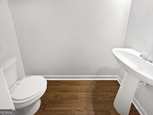 bathroom with toilet and wood-type flooring