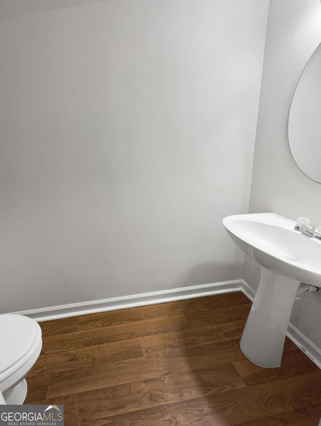 bathroom with hardwood / wood-style floors and toilet