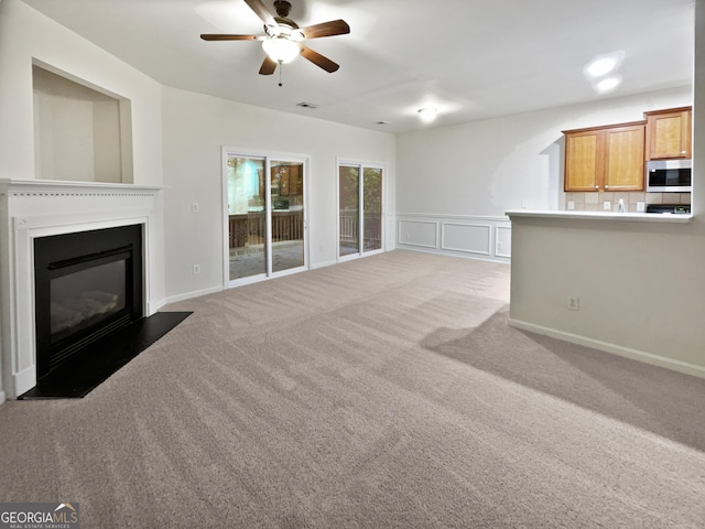 unfurnished living room with ceiling fan and light carpet