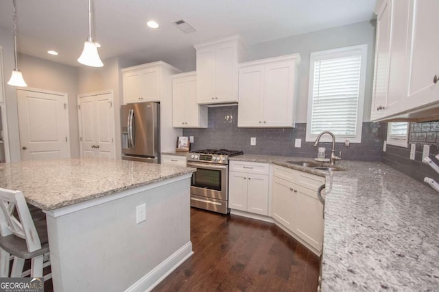 kitchen featuring backsplash, sink, appliances with stainless steel finishes, dark wood-type flooring, and white cabinets