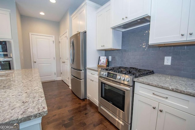 kitchen with backsplash, dark hardwood / wood-style flooring, light stone countertops, white cabinetry, and stainless steel appliances