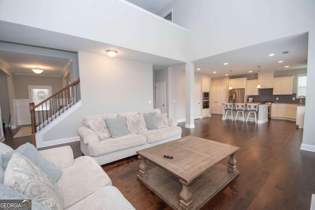 living room featuring a high ceiling and dark wood-type flooring