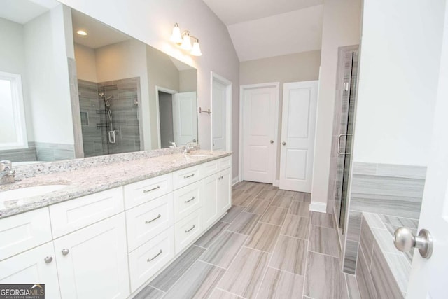 bathroom featuring tile patterned flooring, walk in shower, vanity, and lofted ceiling