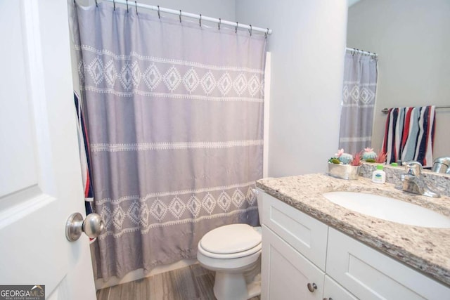 bathroom with toilet, vanity, and curtained shower