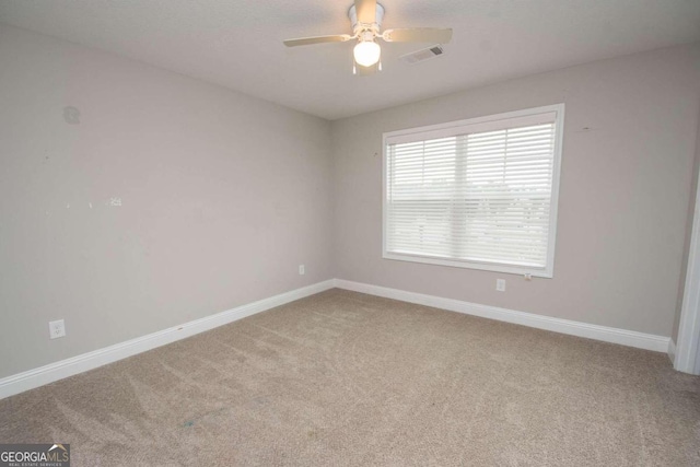 unfurnished room with light colored carpet and ceiling fan