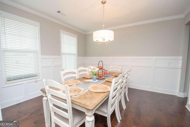 dining space featuring a notable chandelier, dark wood-type flooring, and ornamental molding