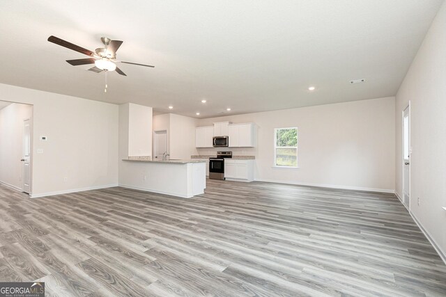 unfurnished living room with light hardwood / wood-style floors and ceiling fan