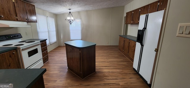 kitchen featuring pendant lighting, a textured ceiling, wood finished floors, white appliances, and under cabinet range hood