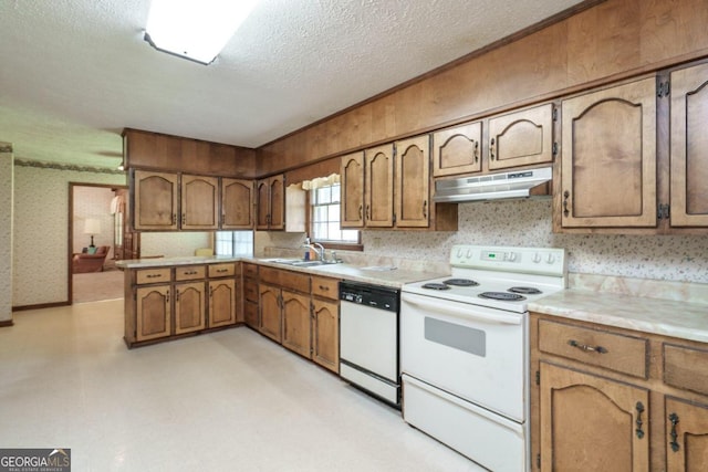 kitchen with sink, kitchen peninsula, a textured ceiling, and white appliances