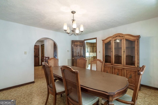 carpeted dining room featuring a textured ceiling and a notable chandelier