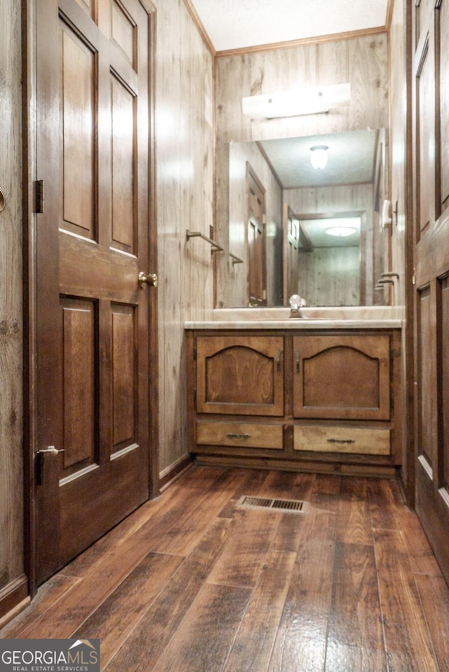 bathroom featuring wood walls, vanity, and hardwood / wood-style floors