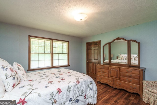 bedroom with a textured ceiling and dark hardwood / wood-style flooring