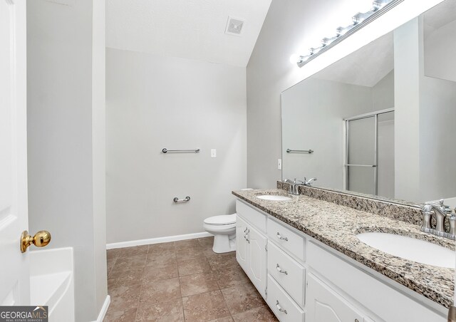 bathroom featuring vanity, tile patterned flooring, lofted ceiling, toilet, and walk in shower