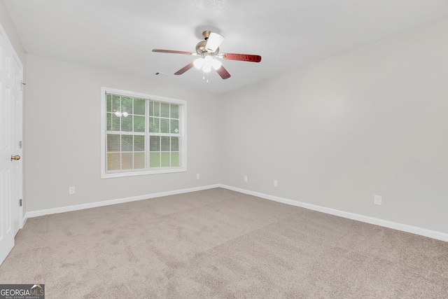 carpeted spare room with ceiling fan