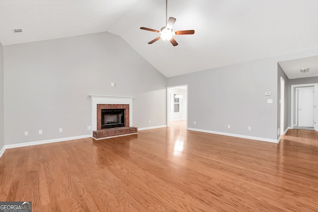 unfurnished living room featuring a fireplace, light hardwood / wood-style flooring, ceiling fan, and high vaulted ceiling