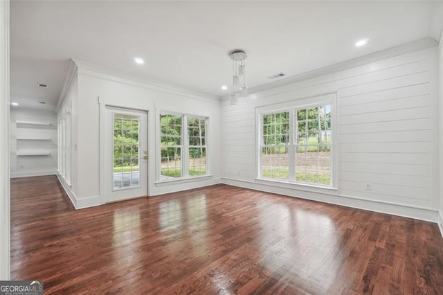 interior space featuring dark wood-type flooring, ornamental molding, and built in shelves