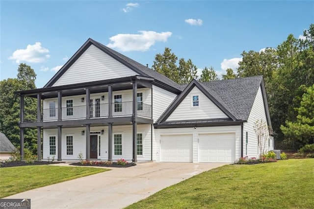 view of front of home featuring a balcony, a garage, and a front yard