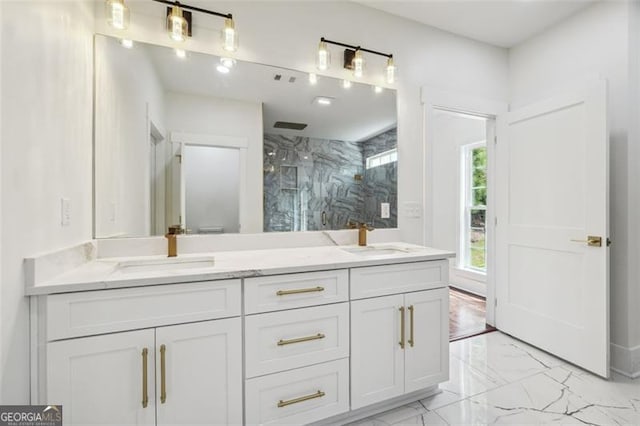 bathroom with tile patterned flooring, tiled shower, and vanity