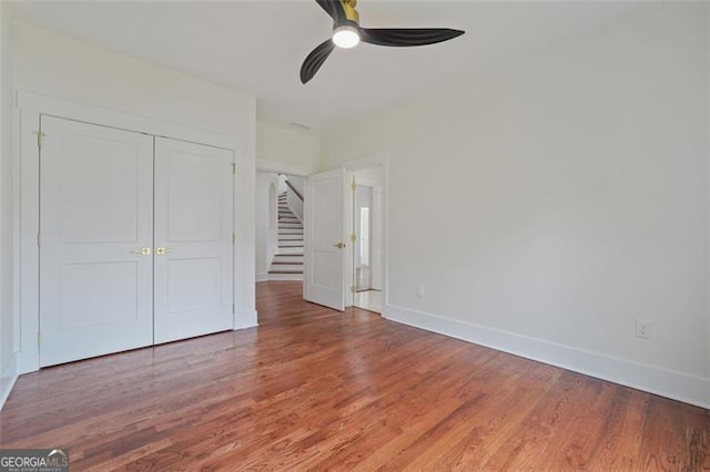 unfurnished bedroom with a closet, ceiling fan, and wood-type flooring