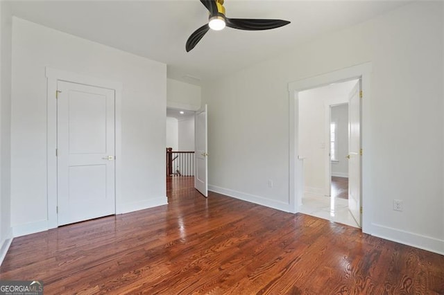 unfurnished bedroom with ceiling fan and wood-type flooring