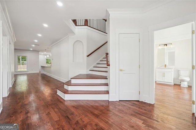 staircase featuring ornamental molding and hardwood / wood-style flooring