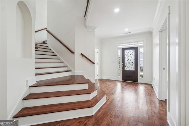 entryway with crown molding and wood-type flooring