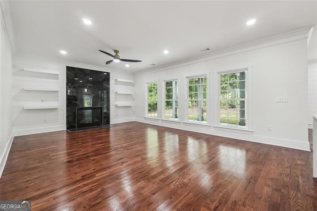 unfurnished living room with ceiling fan, built in shelves, and dark wood-type flooring