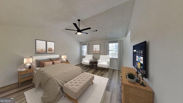 bedroom with lofted ceiling, dark wood-style flooring, visible vents, and a textured ceiling