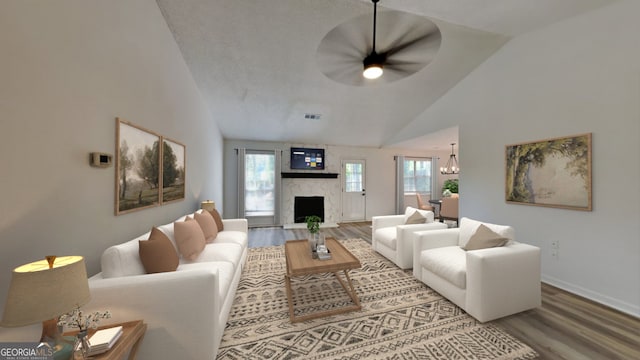 living room with plenty of natural light, hardwood / wood-style floors, a high end fireplace, and high vaulted ceiling