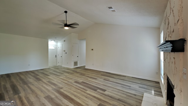 unfurnished living room with lofted ceiling, light wood finished floors, visible vents, and a ceiling fan