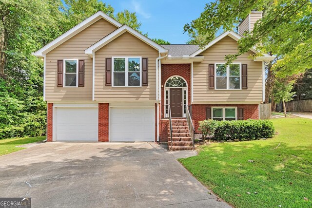 raised ranch with a front lawn and a garage