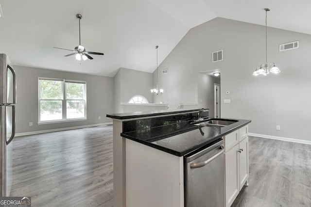 kitchen with sink, light hardwood / wood-style floors, ceiling fan with notable chandelier, stainless steel appliances, and a center island with sink