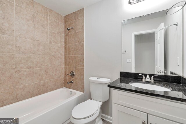 full bathroom with toilet, tiled shower / bath combo, and vanity