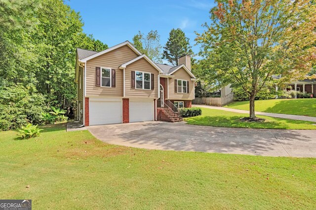 split foyer home featuring a garage and a front yard