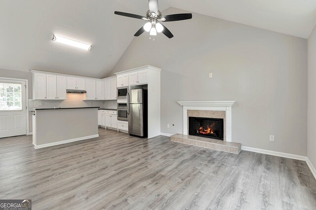 kitchen featuring light hardwood / wood-style floors, high vaulted ceiling, stainless steel appliances, and white cabinets