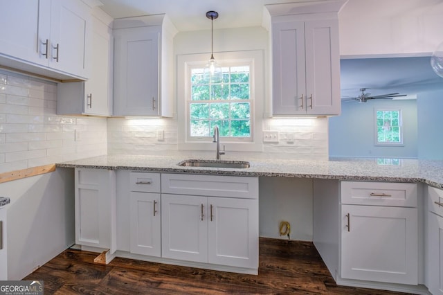 kitchen featuring white cabinetry, sink, ceiling fan, dark hardwood / wood-style flooring, and pendant lighting