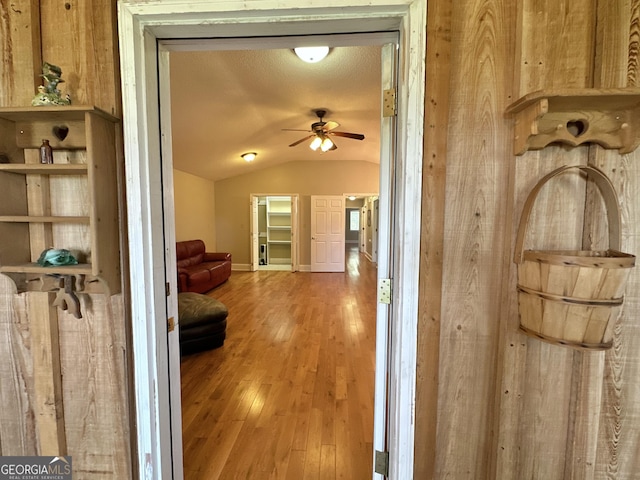 hall featuring lofted ceiling and wood finished floors