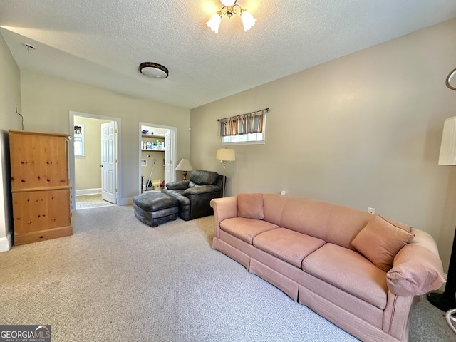 carpeted living area with baseboards and a textured ceiling