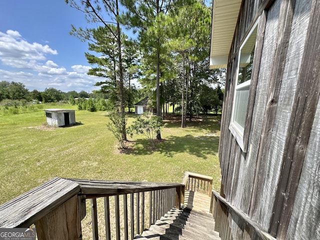 view of yard with an outbuilding, a deck, and a storage shed