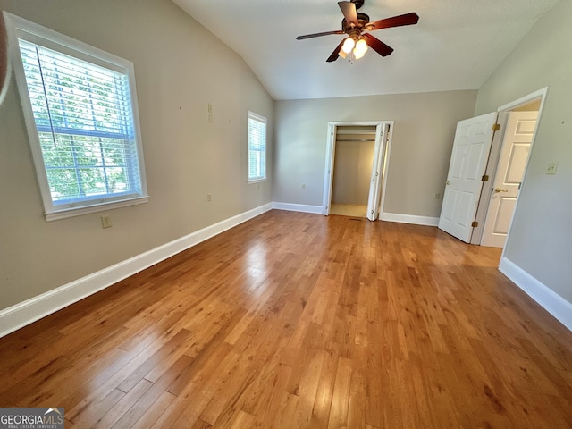 unfurnished bedroom featuring light wood-style floors, vaulted ceiling, and baseboards