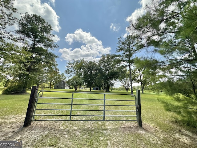 view of gate with a lawn