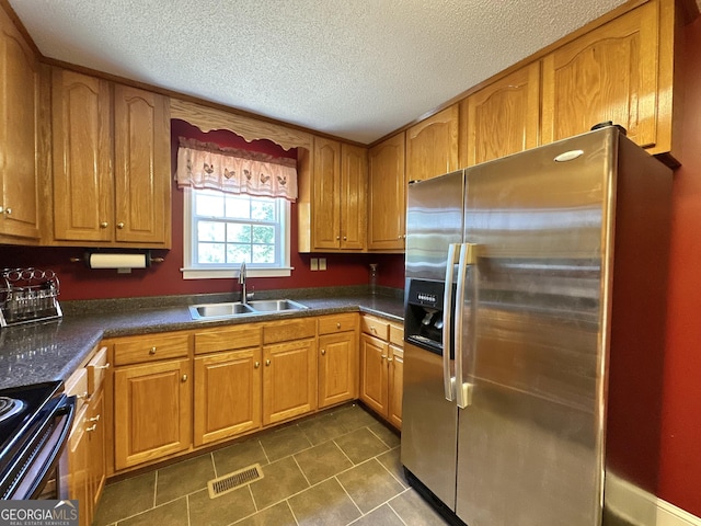 kitchen featuring dark countertops, visible vents, a sink, and stainless steel fridge with ice dispenser