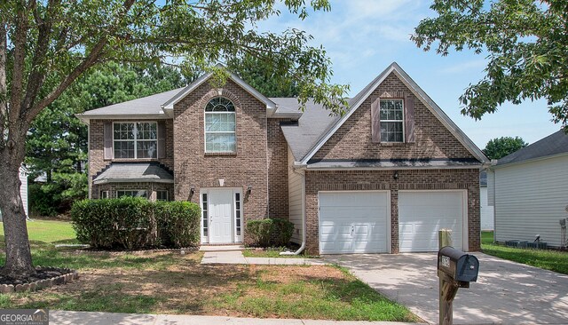 traditional-style house featuring a garage, concrete driveway, and brick siding