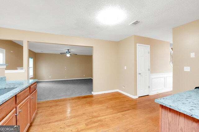 carpeted living room with a textured ceiling and ceiling fan