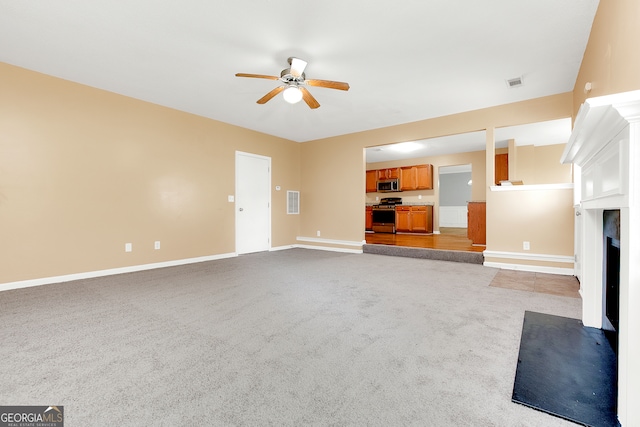 unfurnished living room featuring light colored carpet and ceiling fan