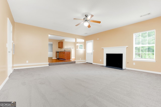 unfurnished living room featuring ceiling fan and carpet flooring