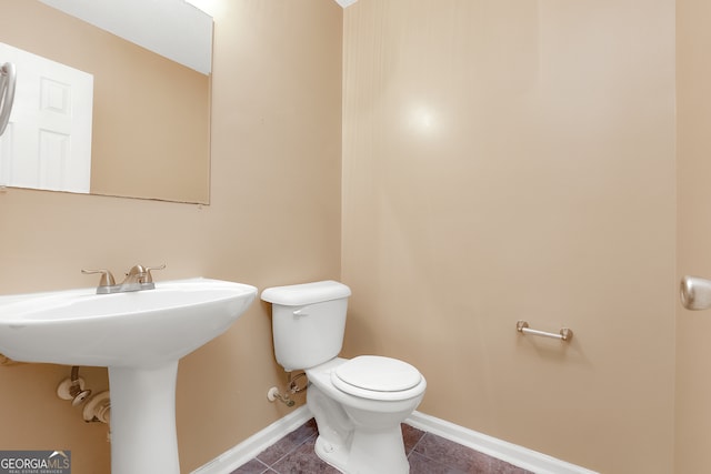 bathroom with sink, toilet, and tile patterned floors