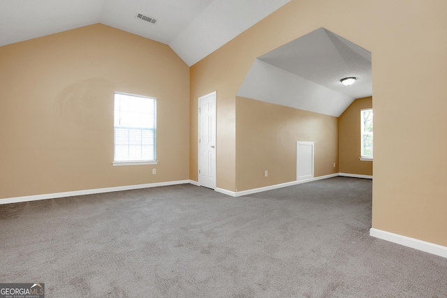 interior space with vaulted ceiling, carpet, and visible vents