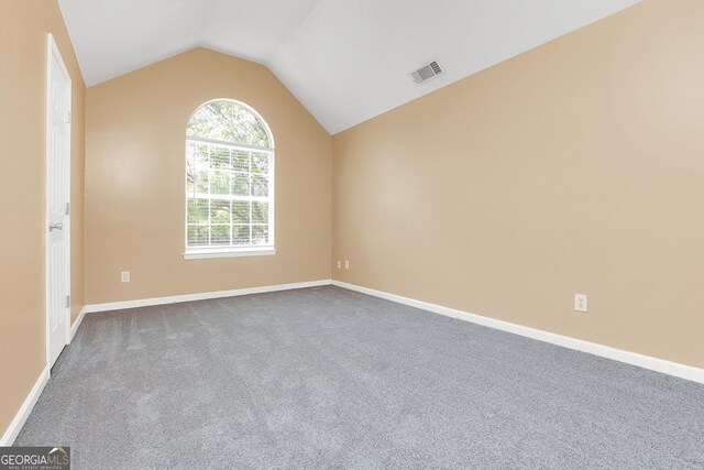 empty room with lofted ceiling and carpet